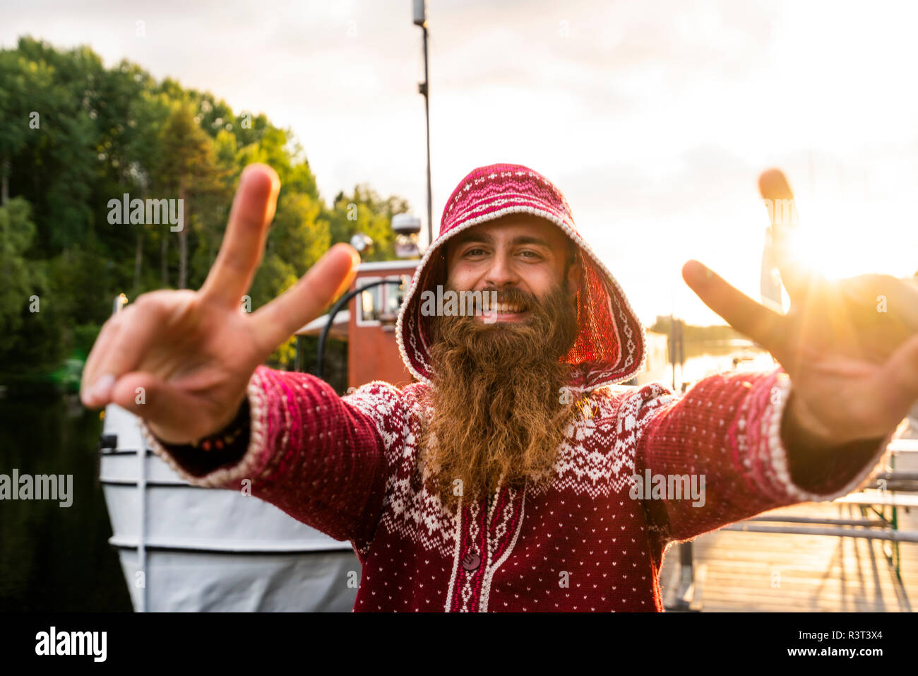 La Finlande, Kajaani, joyeux jeune homme. Le port de veste, houded standing on Jetty, faire les gestes de la main Banque D'Images