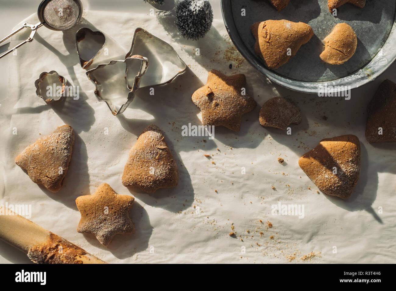 Les biscuits de Noël et d'un emporte-pièce sur du papier sulfurisé Banque D'Images