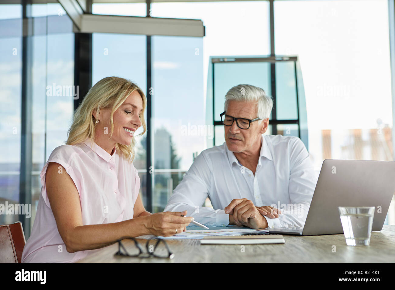 Businessman snd woman sitting in office, discussing project Banque D'Images