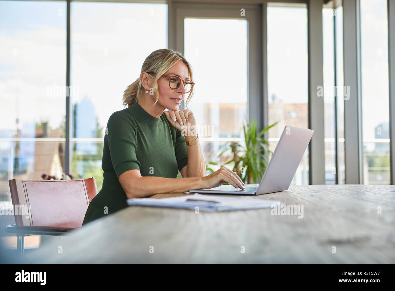 Mature Woman using laptop sur la table à la maison Banque D'Images
