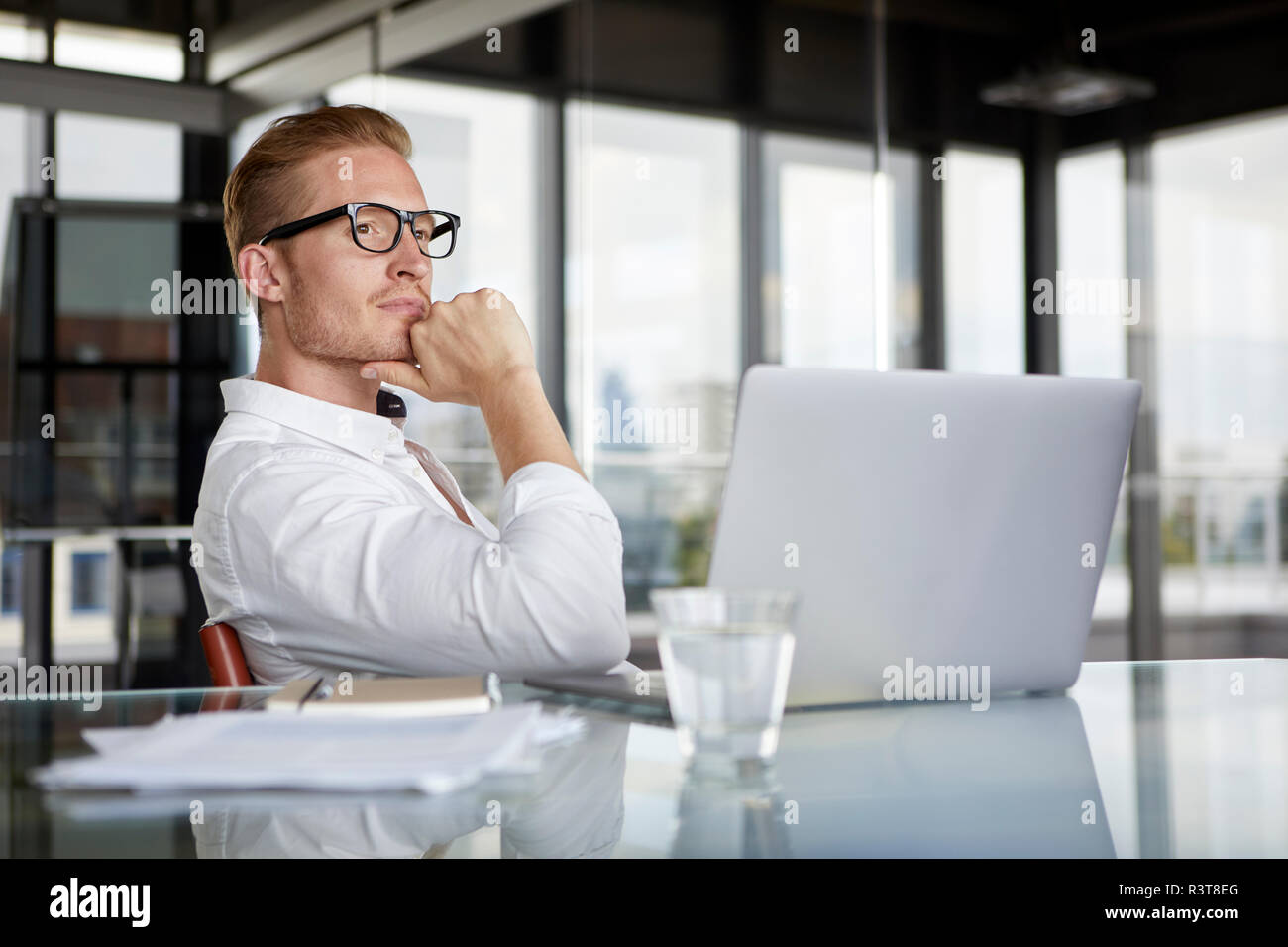 Businessman with laptop on desk in office penser Banque D'Images