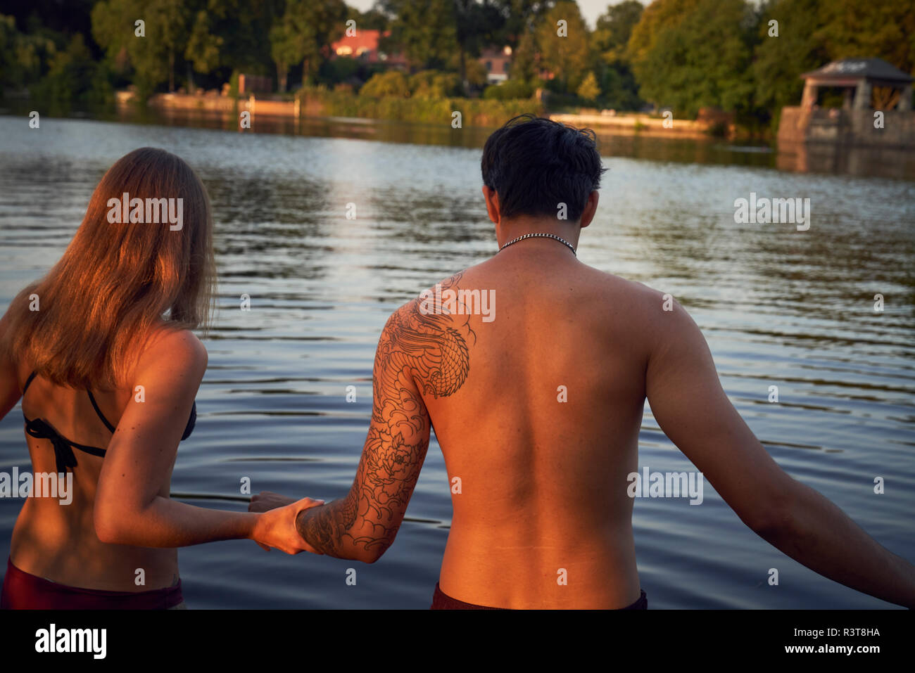 Jeune couple d'entrer dans un lac, baignade Banque D'Images