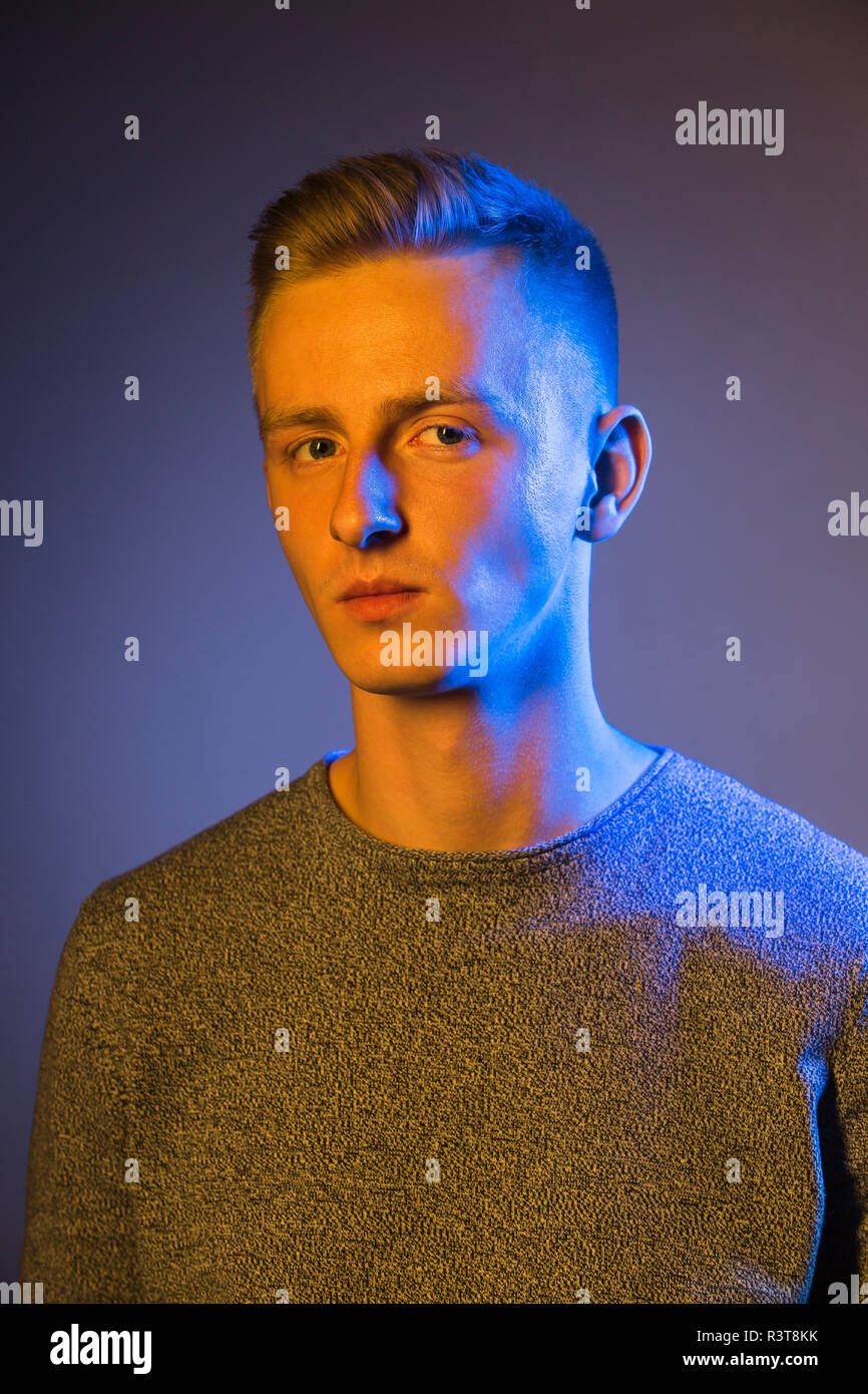 Portrait de jeune homme sérieux à la lumière bleue Banque D'Images