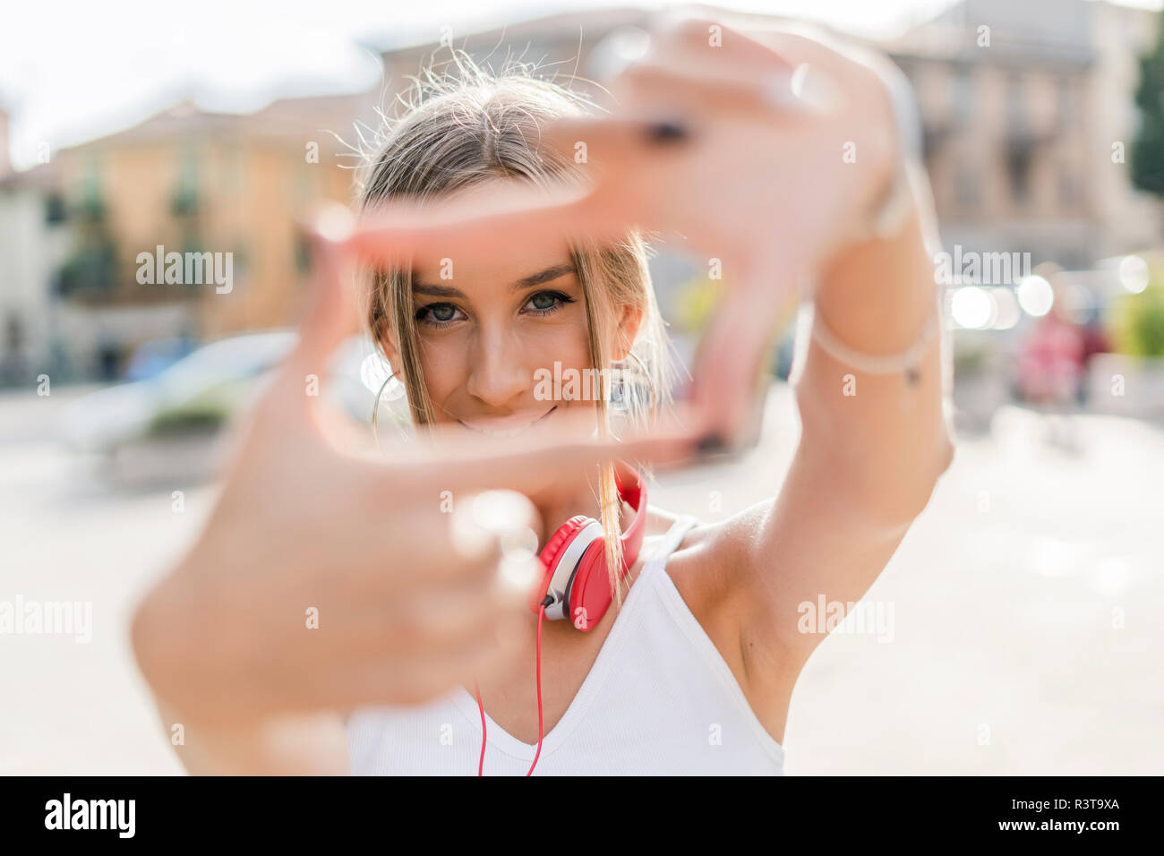 Portrait of smiling teenage girl making a finger frame dans la ville Banque D'Images