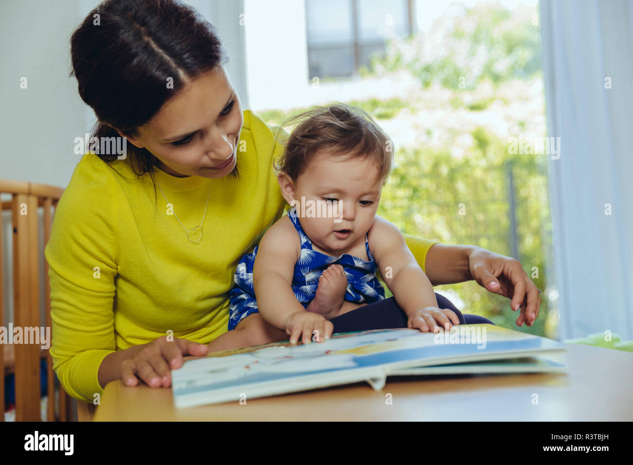 Mère et fille à la recherche de livre pour enfants Banque D'Images