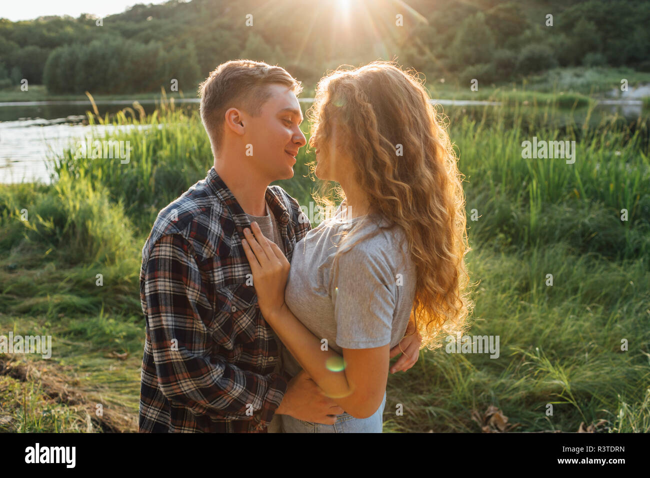 Couple romantique passer du temps dans la nature, les baisers au coucher du soleil Banque D'Images