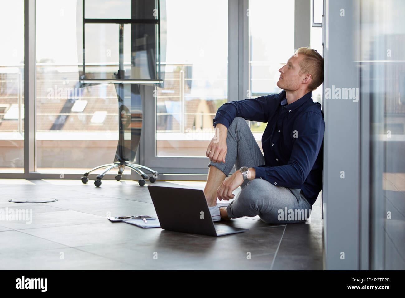 Portrait sur le sol à côté d'un ordinateur portable Banque D'Images