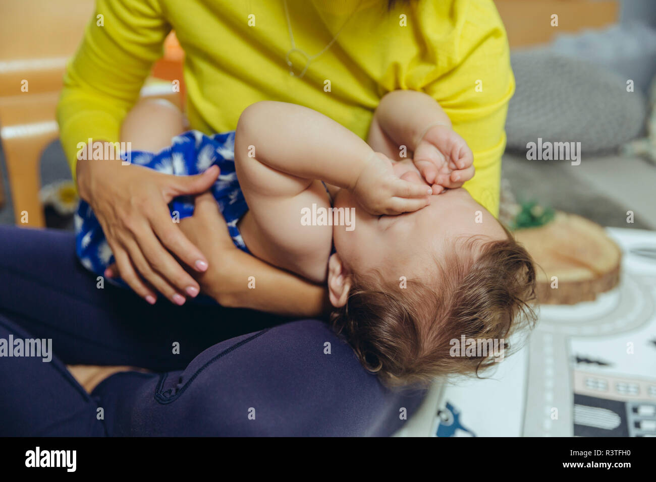 Bébé fille frotte les yeux fatigués au tour de mère Banque D'Images