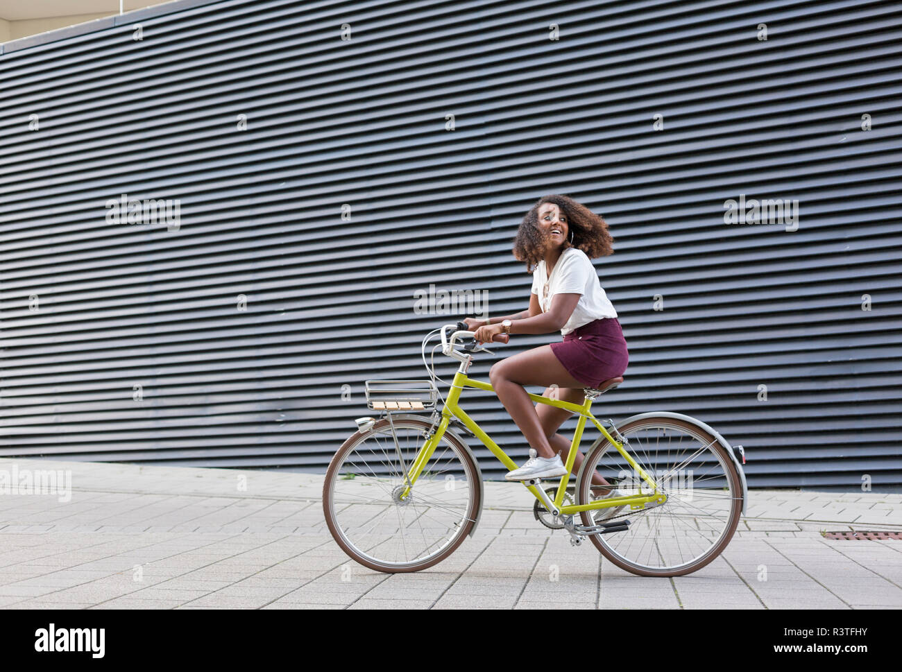 Smiling young woman riding bicycle Banque D'Images