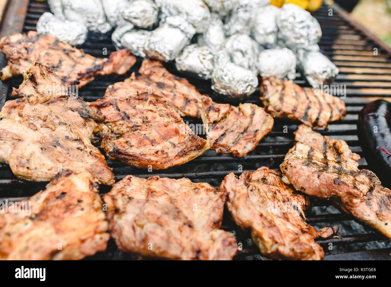 Saucisses, porc et poulet rôti sur un barbecue, vu de dessus. Banque D'Images