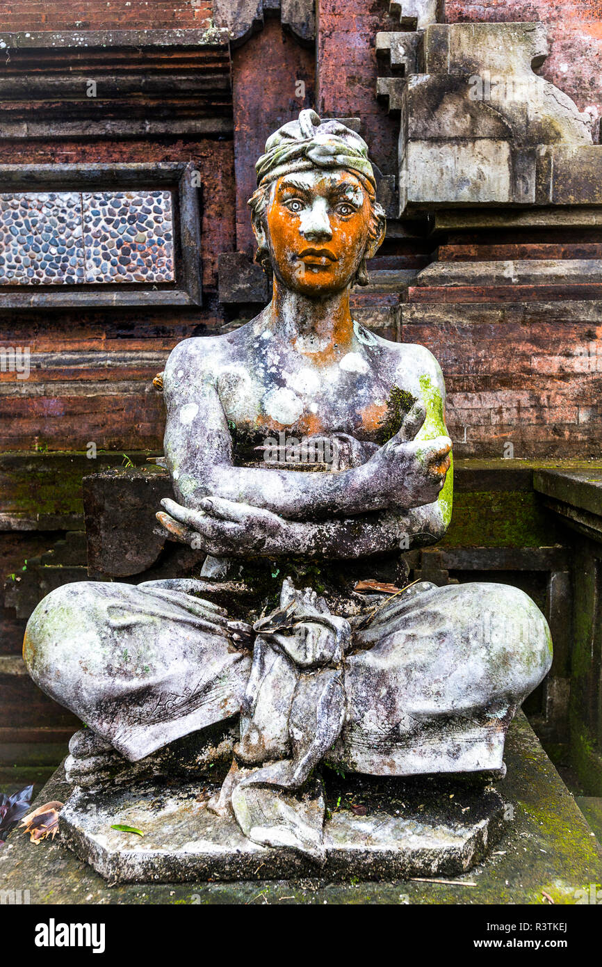 Statue de pierre vertical au Temple Hindou, Bali avec bras croisés et les jambes. Banque D'Images