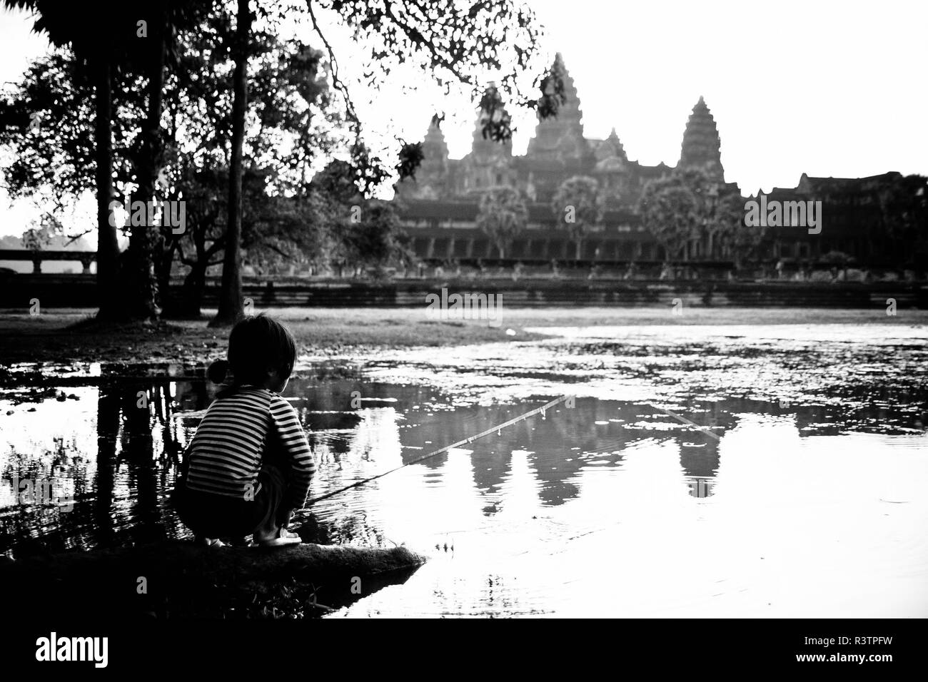 Siem Reap, Cambodge - le 12 septembre 2010 : Lonely Girl regarder le lever du soleil sur le lac en face du temple d'Angkor Wat Banque D'Images