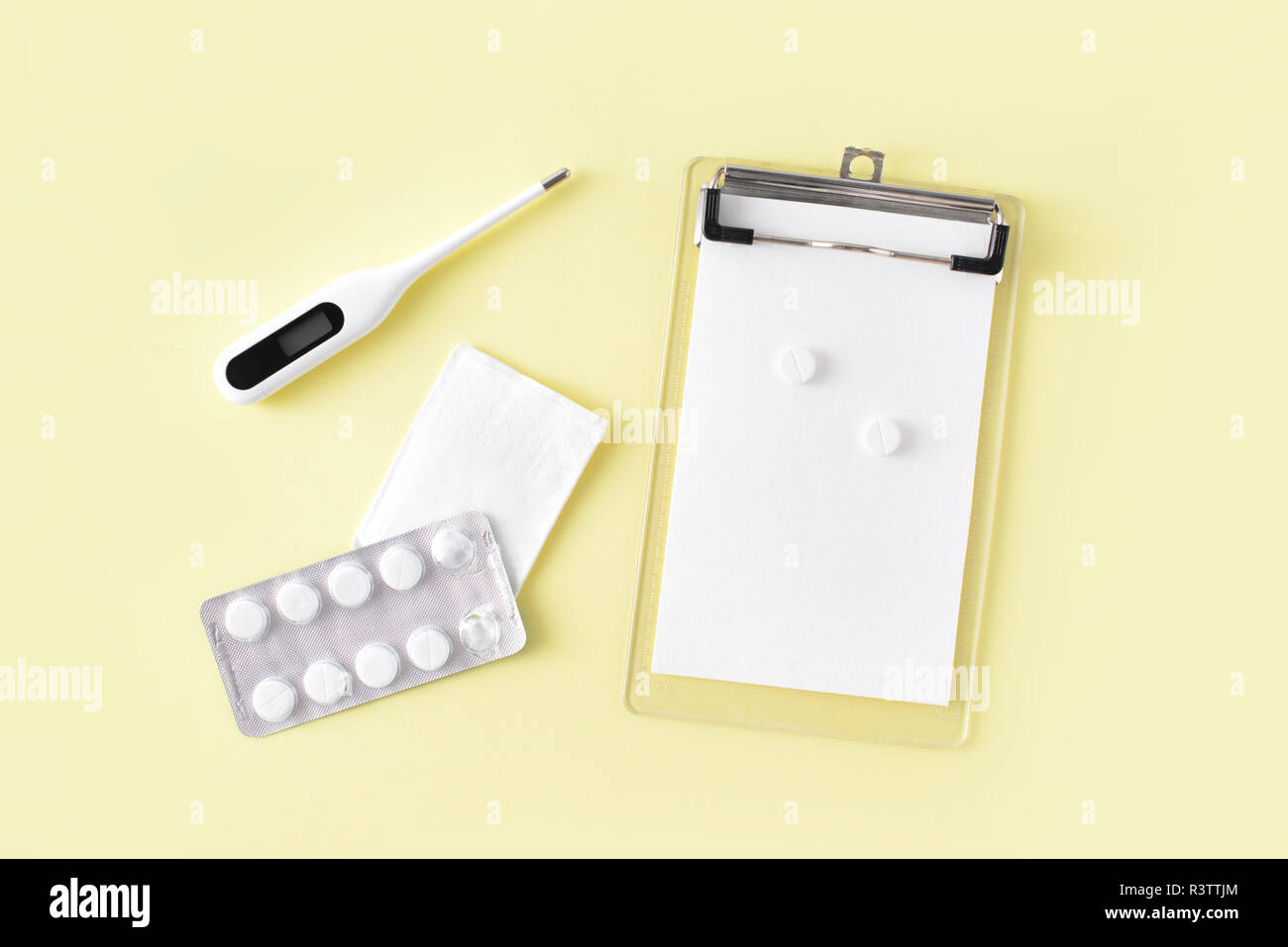 Comprimés, thermomètre et remarque pour la recette sur fond jaune. Le traitement du rhume et de la grippe. Mise à plat, vue du dessus. Banque D'Images