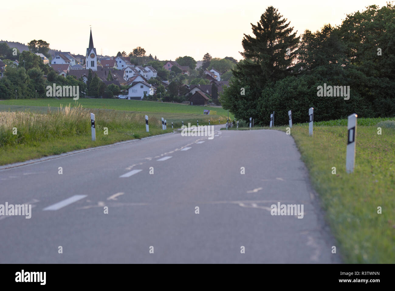 Petite route sinueuse qui mène au petit village suisse Banque D'Images