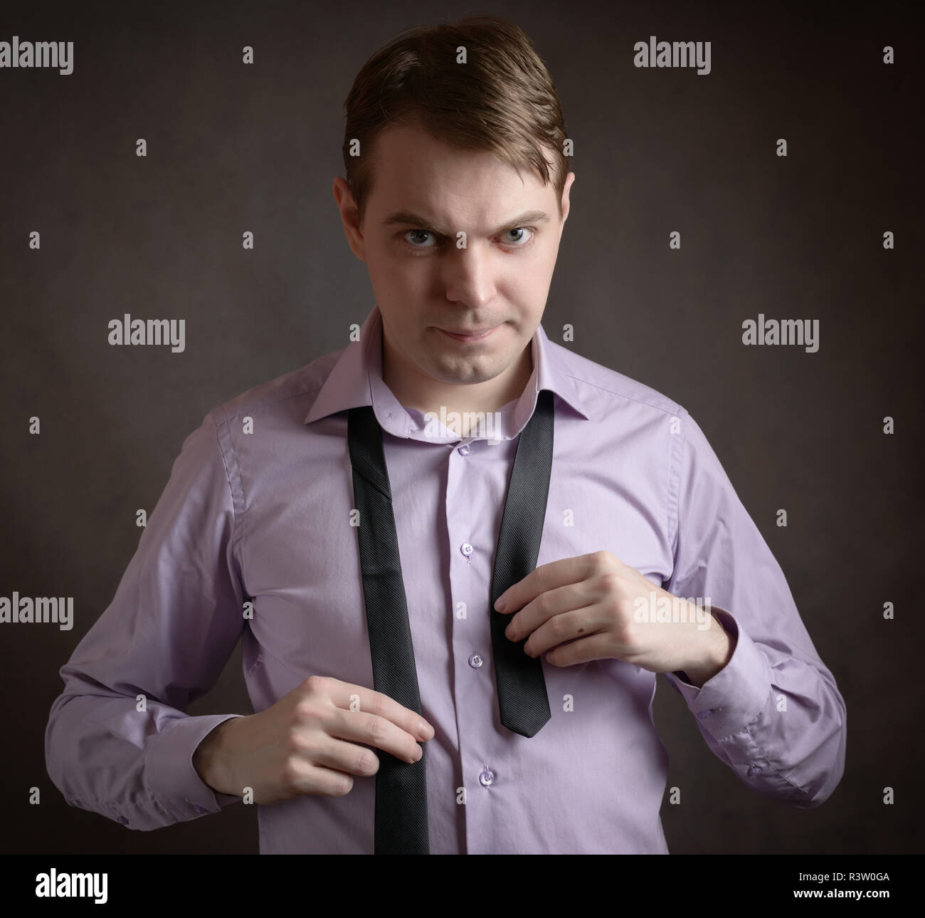 Jeune homme en chemise rose nouant la cravate Photo Stock Alamy