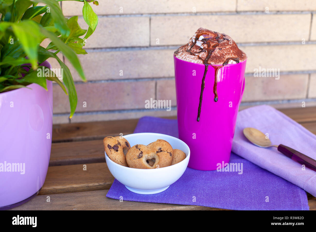 Cookies et cappuccino en plein air - petit-déjeuner italien en violet Banque D'Images