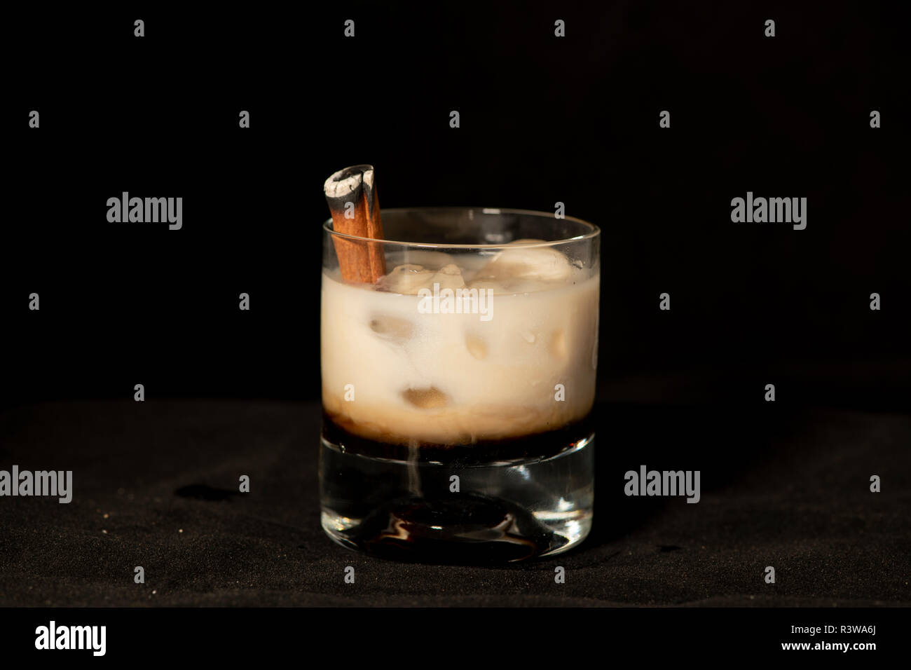 Cocktail avec de la cannelle en flammes, kahlua Baileys Irish Cream et sambuca avec fond noir isolé Banque D'Images