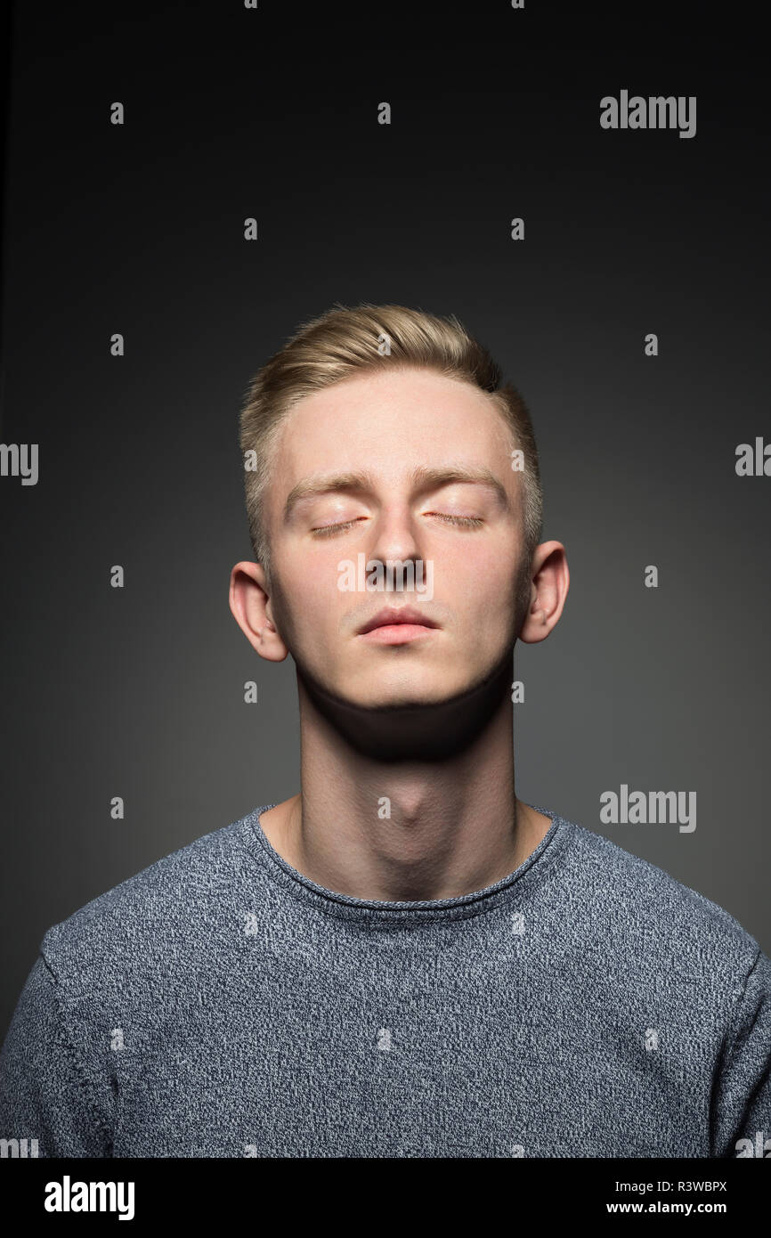 Portrait de jeune homme blond avec les yeux fermé Banque D'Images