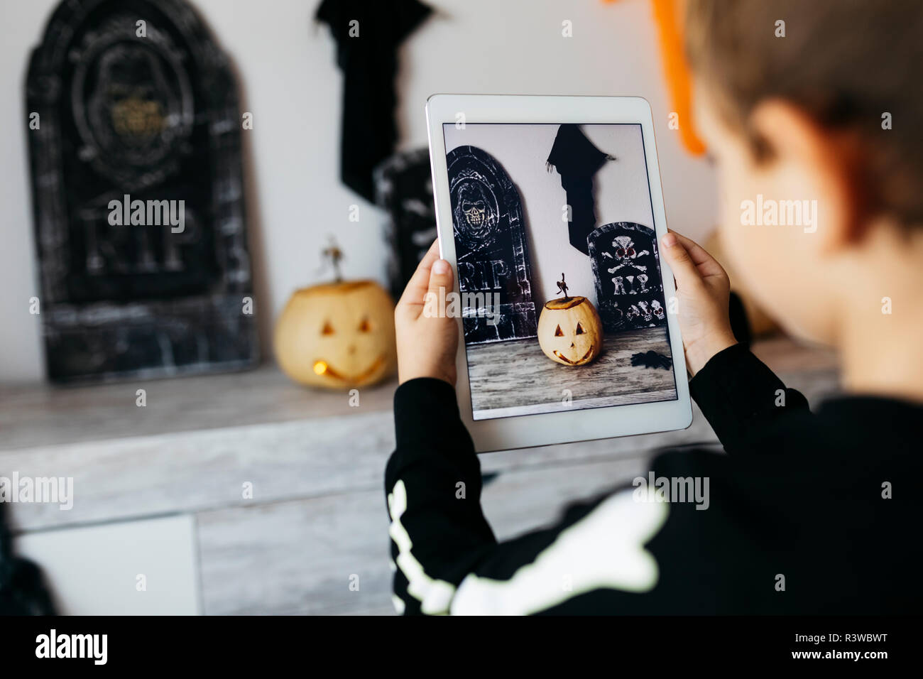 Little Boy taking photo de décoration Halloween with digital tablet Banque D'Images