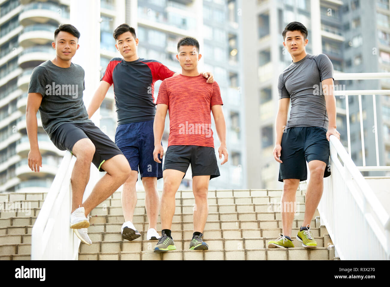 Portrait en extérieur d'une équipe de quatre jeunes athlètes asiatiques sur les mesures permanent Banque D'Images