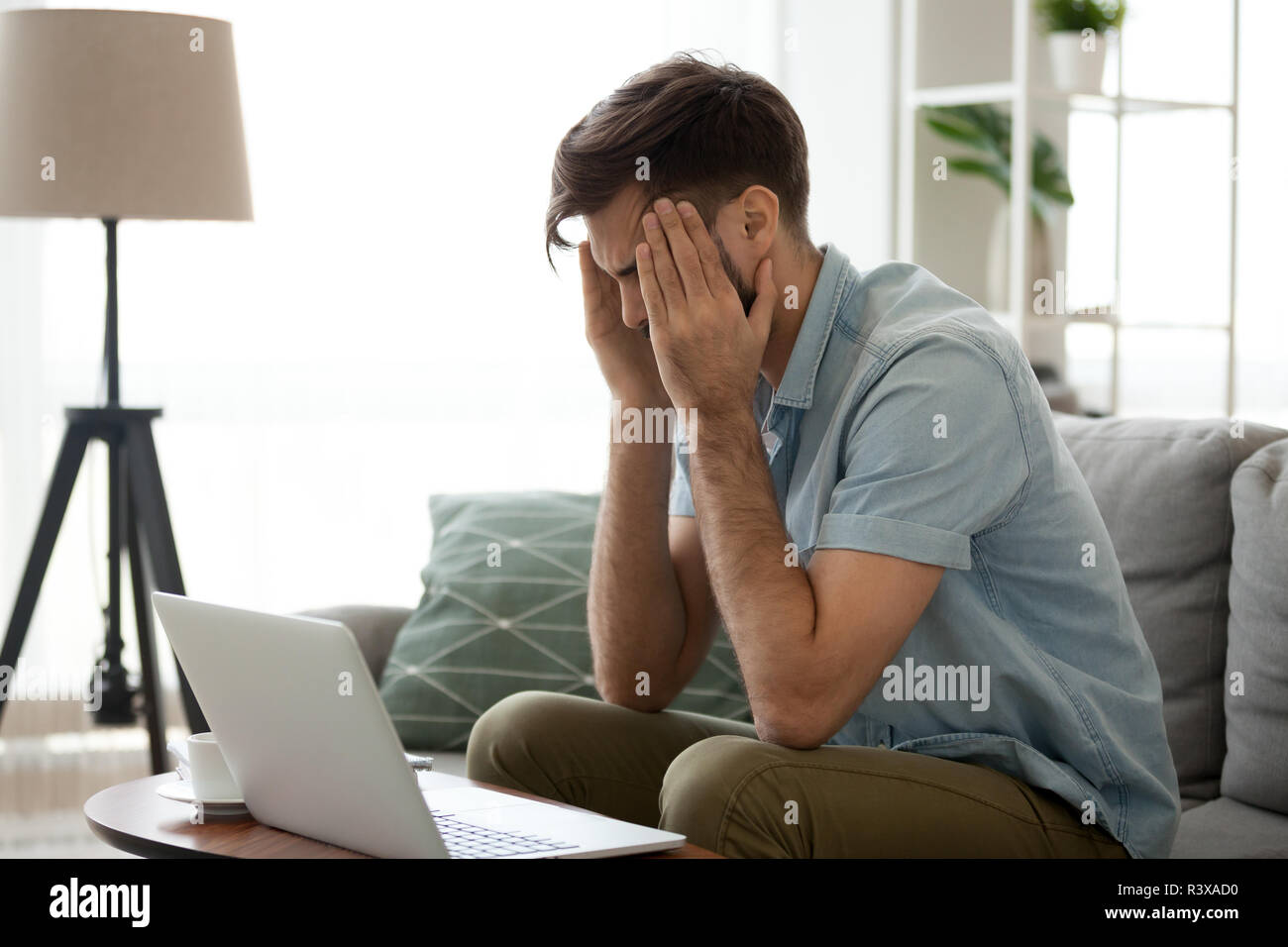 L'homme épuisé souffrent de maux de tête au travail laptop at home Banque D'Images