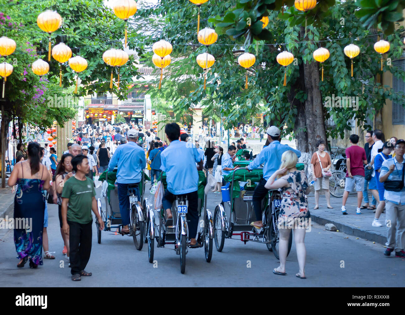 Trishaws vélos-pousse les touristes à cheval autour de l'ancienne ville de Hoi An. Banque D'Images