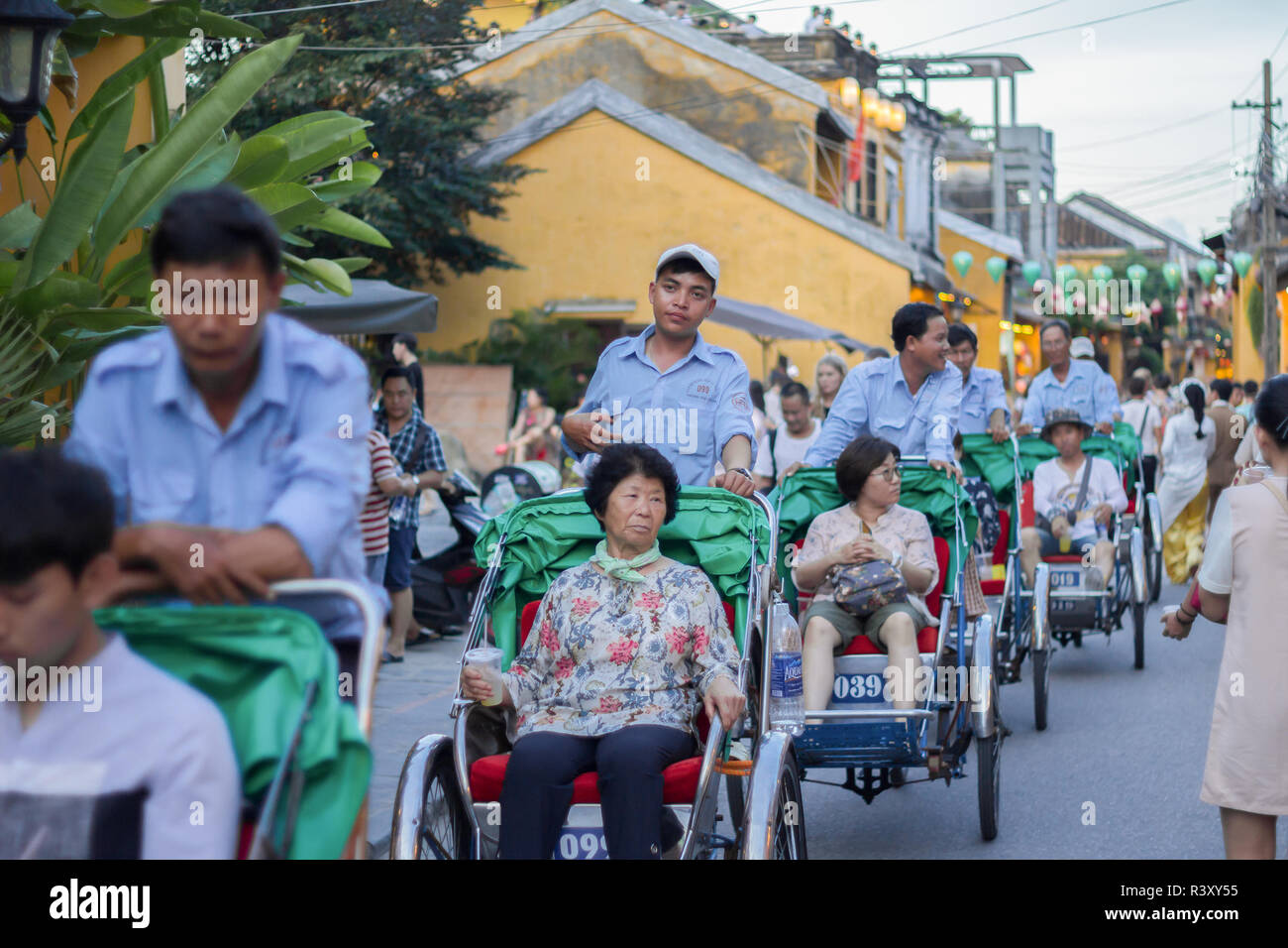 Vélos-pousse les touristes à cheval autour de l'ancienne ville de Hoi An. Banque D'Images