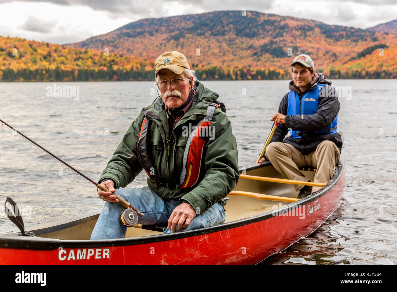 Deux hommes la pêche à la mouche à partir d'un canoë sur Greenough étang dans l'emplacement de Wentworth, New Hampshire. De l'automne. La Forêt du Nord. (MR) Banque D'Images