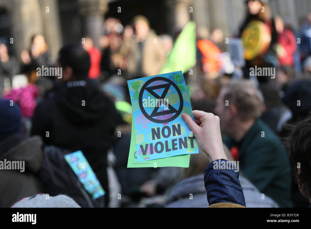 Manchester, UK. 24 Nov 2018. Une brochure de l'Extinction et symbole de rébellion non violente "mots" est considéré comme les manifestants défilent dans les rues de la ville, Manchester, Royaume-Uni, le 24 novembre 2018 Crédit : Barbara Cook/Alamy Live News Banque D'Images