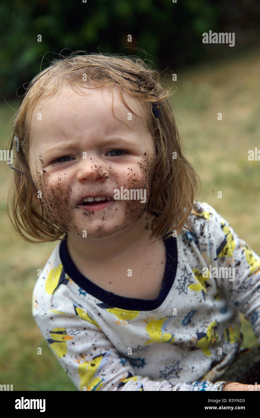 Toddler playing in the dirt in garden Banque D'Images