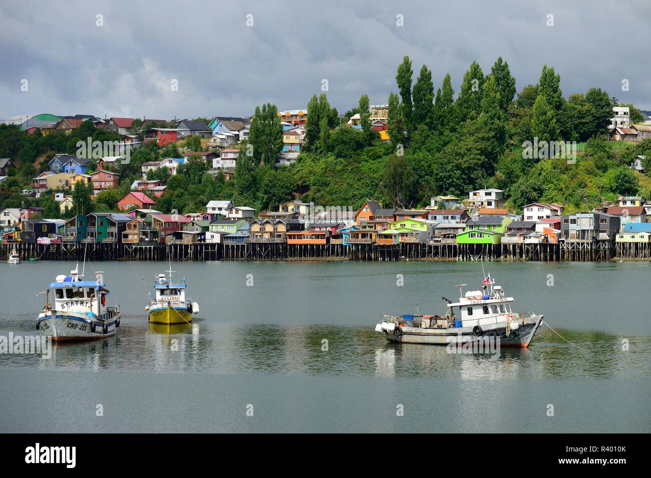 L'ancrage des bateaux de pêche colorés en face de maisons sur pilotis, pile dwellings, appelées palafitos, Castro, île de Chiloé, Chili Banque D'Images