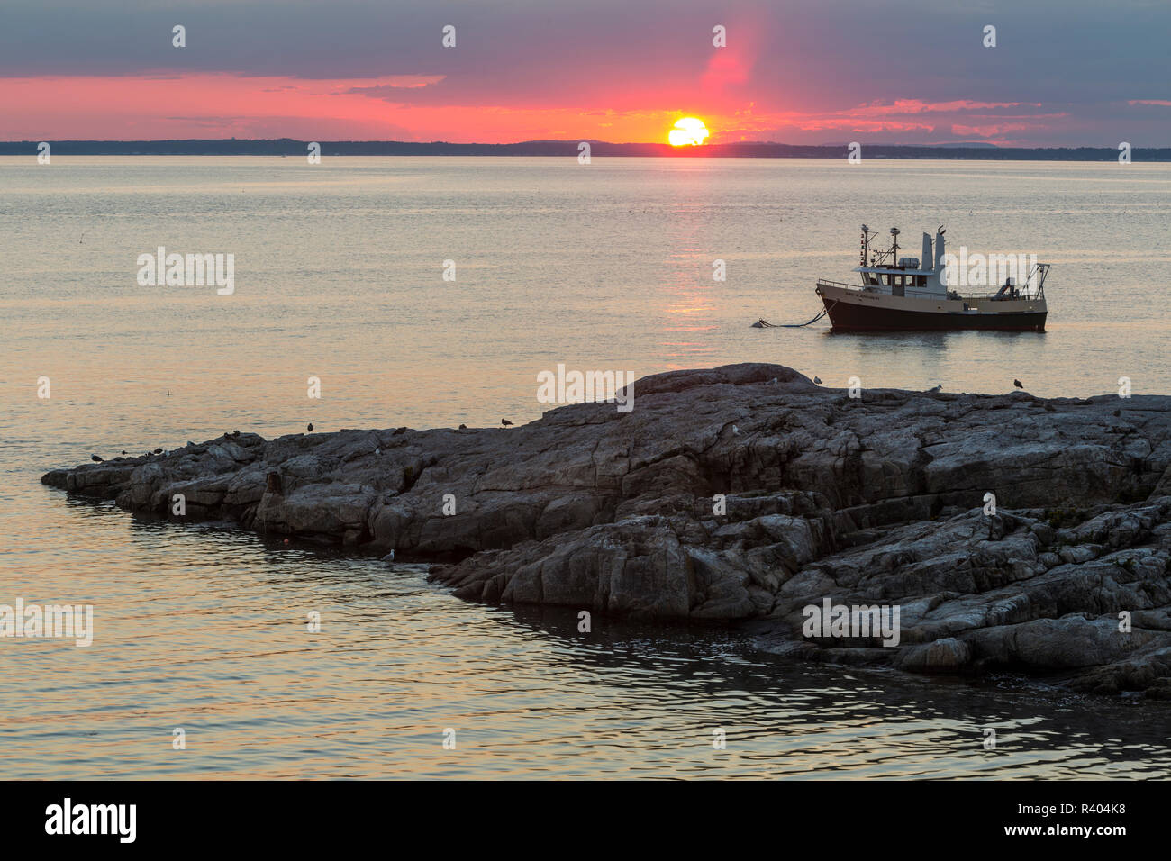 Bateau de pêche au coucher du soleil. L'île de Appledore, Maine. Banque D'Images