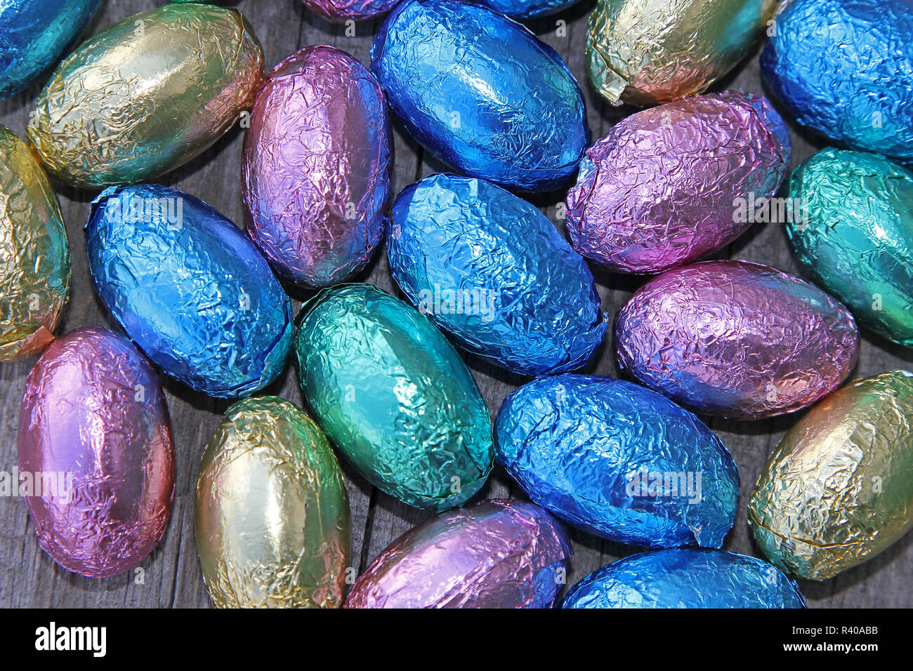 De nombreux petits œufs de pâques en chocolat coloré situé sur bois Banque D'Images