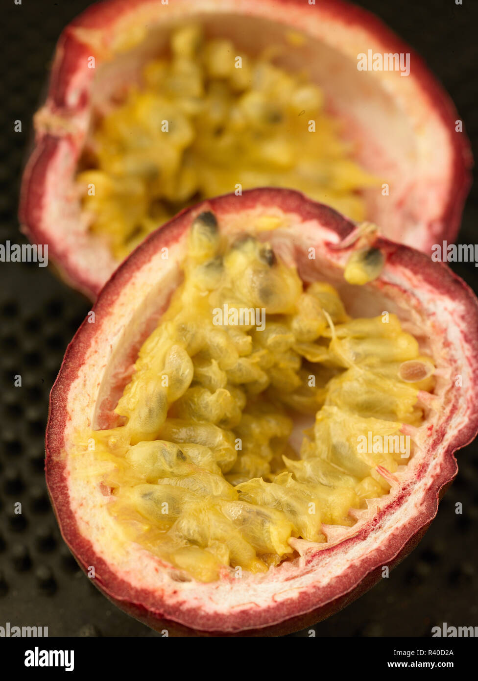 Fruit de la moitié montrant les graines de couleur vive, à proximité de l'alimentation à la photographie sur un fond noir Banque D'Images