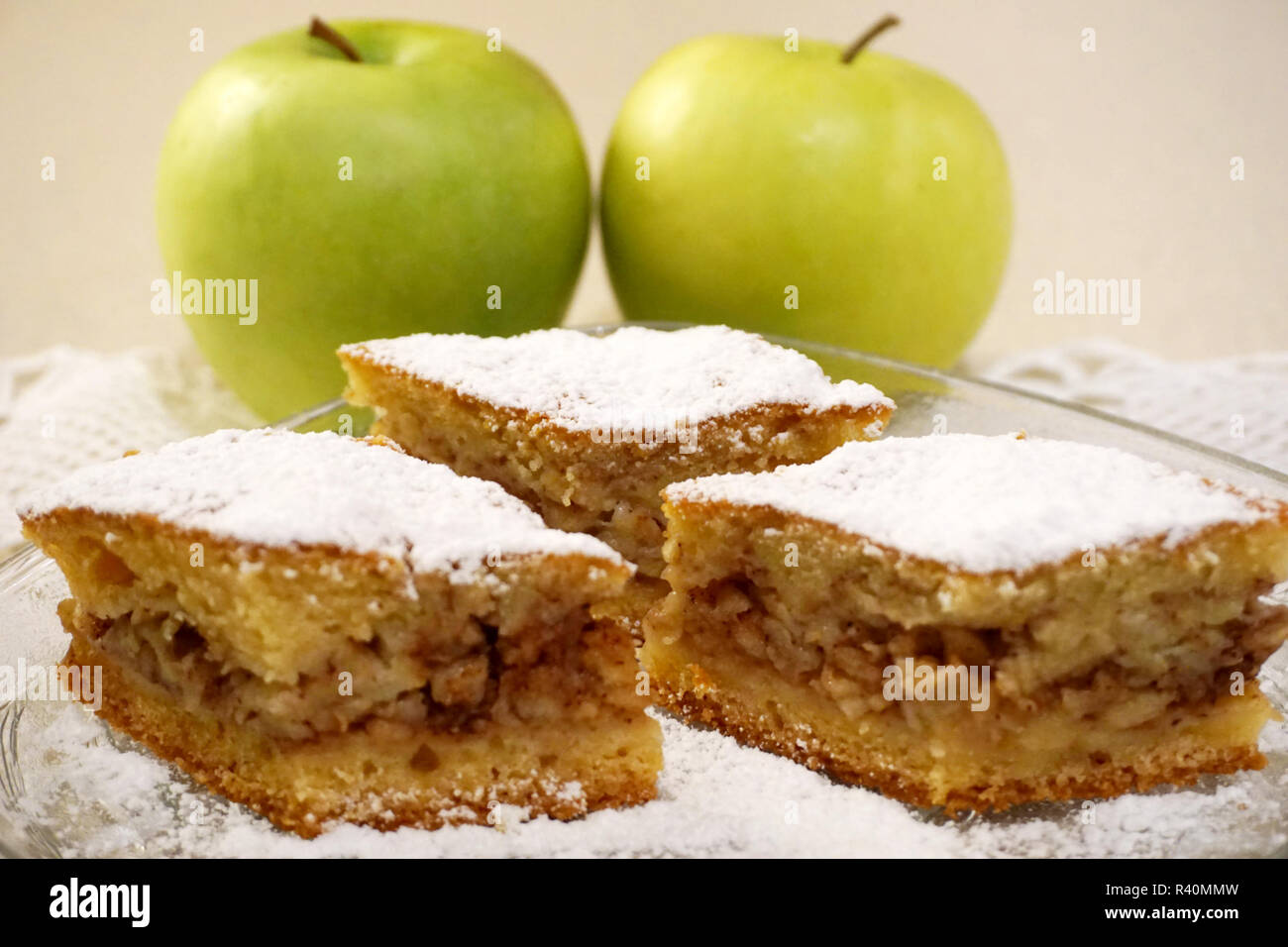 Ingrédients naturels dans accueil boulangerie. Trois morceaux de gâteau aux pommes maison traditionnelle avec deux pommes vertes biologiques dans un contexte Banque D'Images