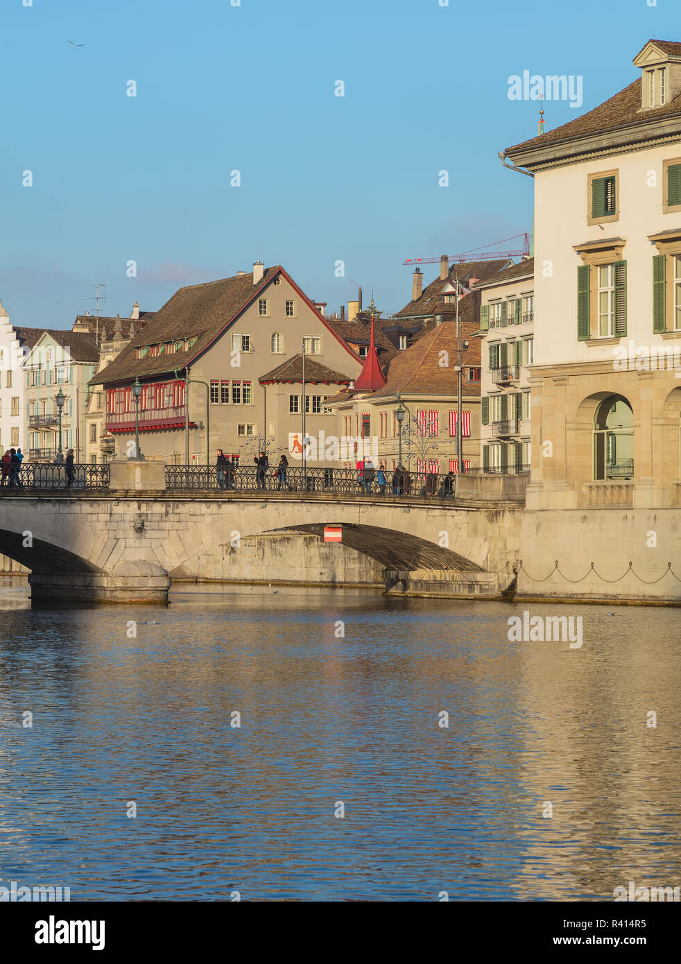 Zurich, Suisse - le 19 décembre 2016 : la rivière Limmat et bâtiments de la vieille ville le long de celui-ci, les gens sur le Munsterbrucke pont sur la rivière. Je Zurich Banque D'Images