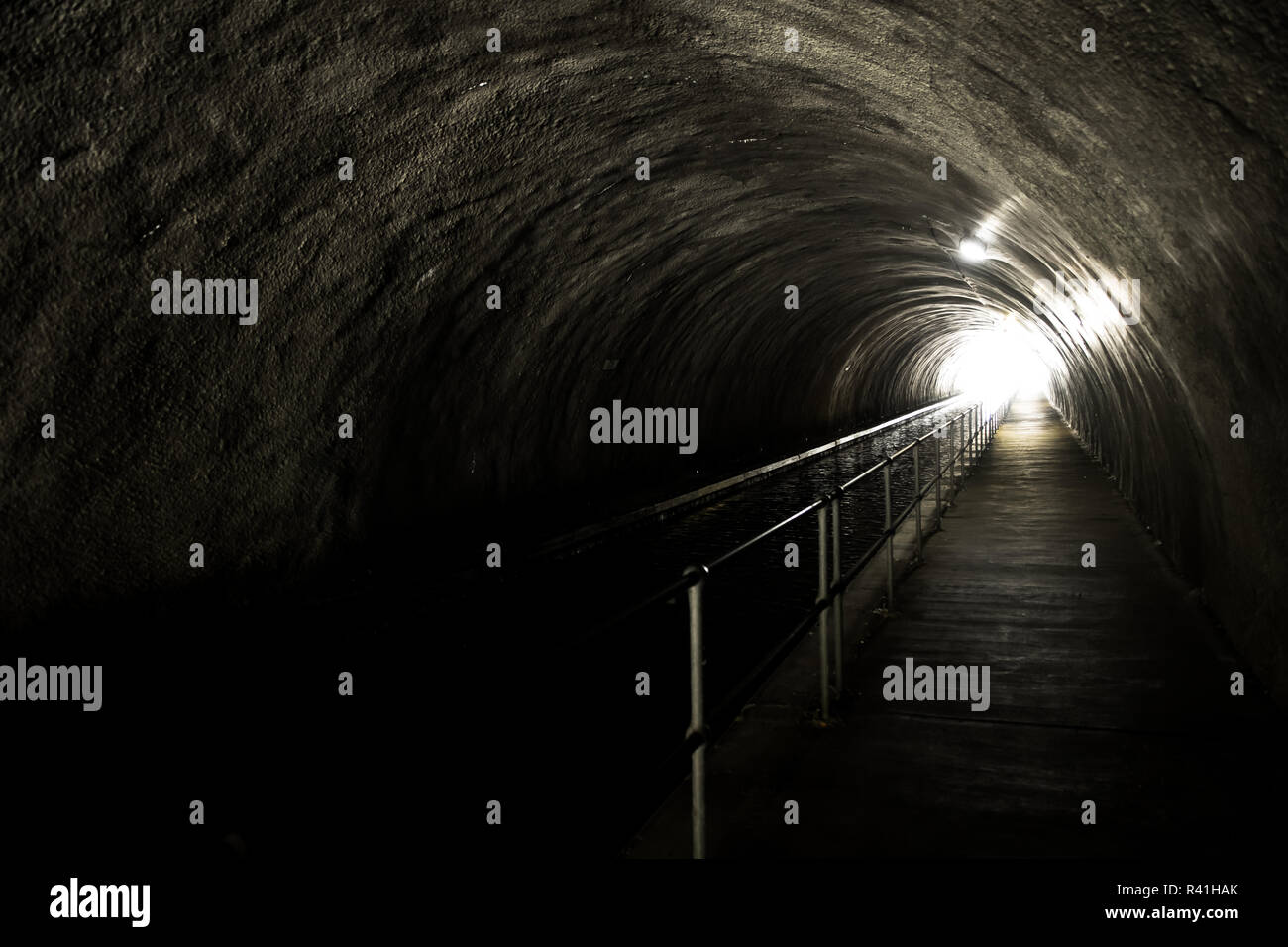 La lumière vive à la fin d'un tunnel sombre et glauque Banque D'Images