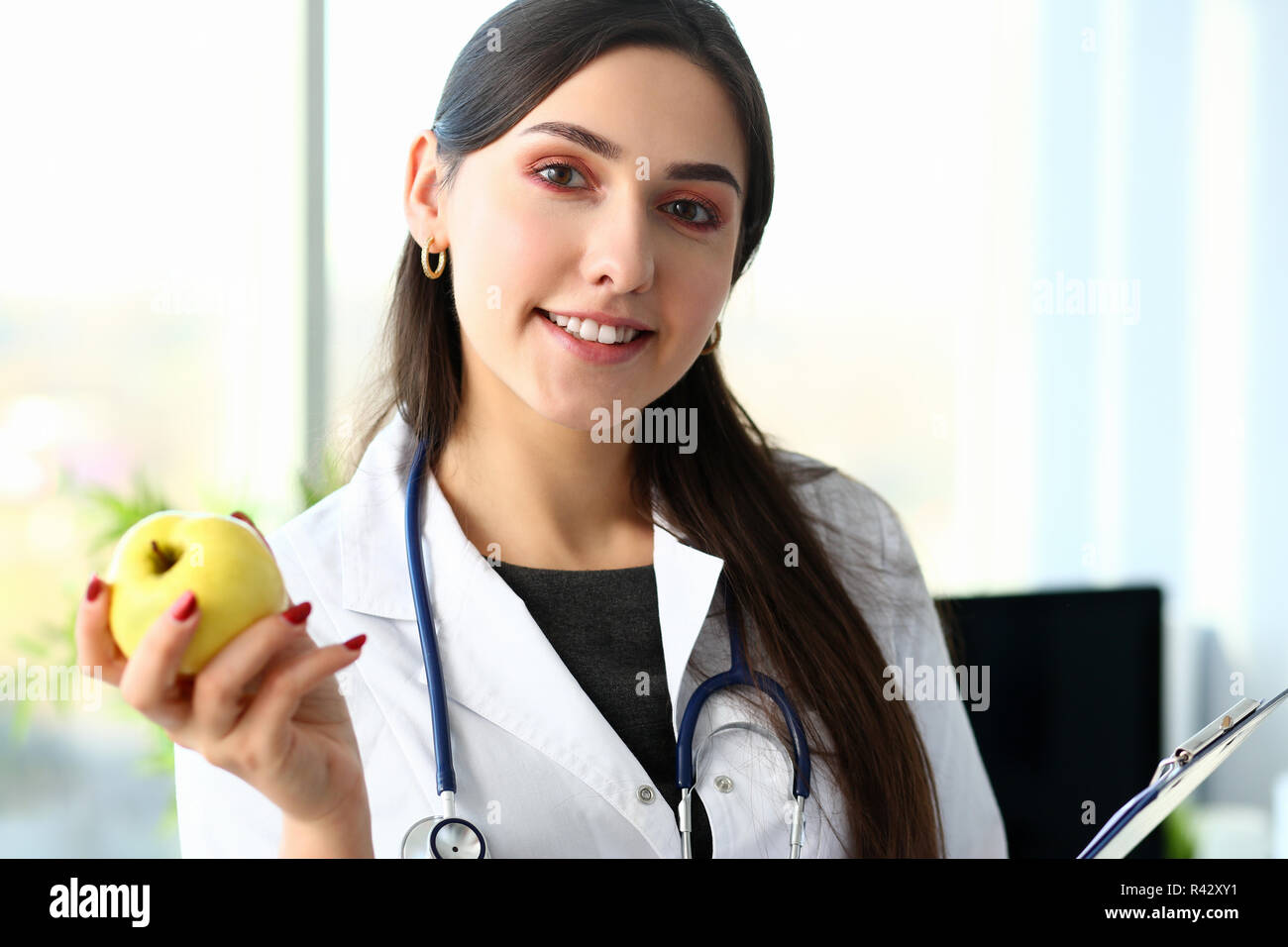 Doctor holding green apple avec copie espace sur bleu Banque D'Images