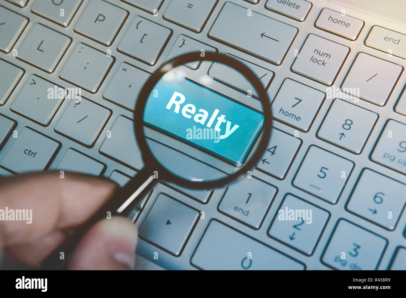 Amplifié bouton bleu Immo vue à travers la loupe sur fond de clavier. Concept de propriété recherche internet services. À la recherche d'agence immobilière en ligne. La recherche d'agent immobilier. Banque D'Images