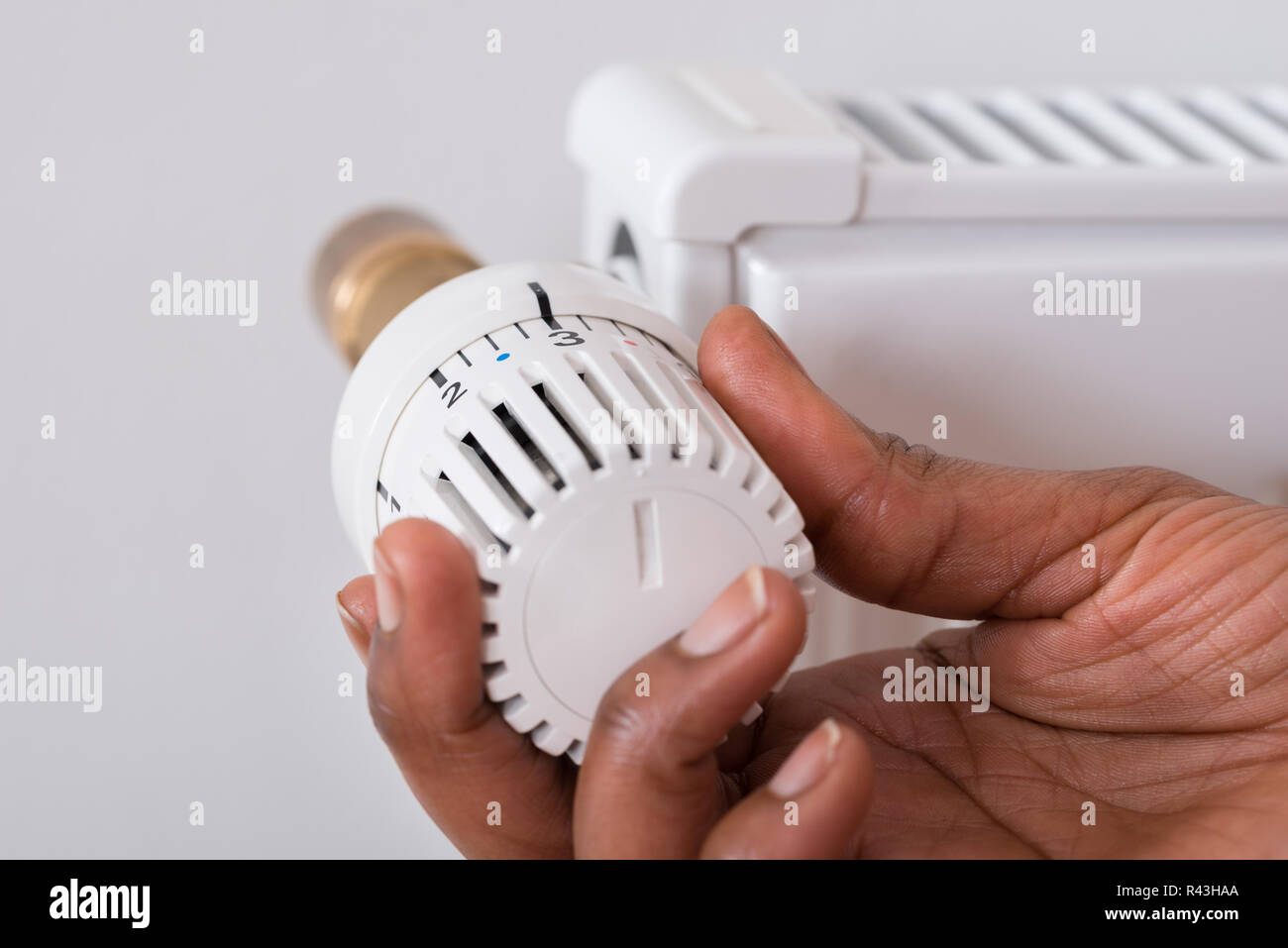 Person's Hand Holding thermostat de radiateur Banque D'Images