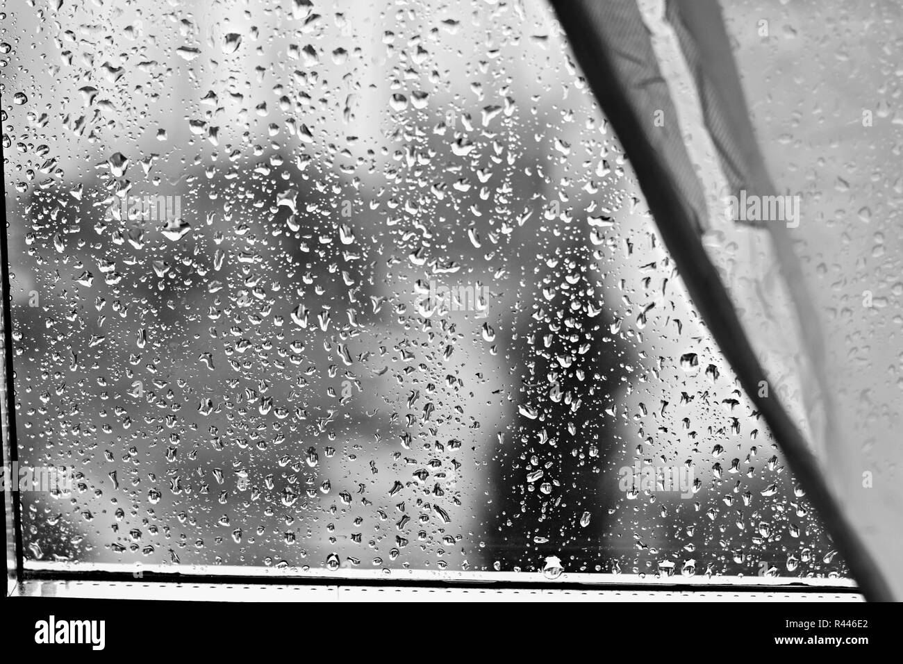 Gouttes de pluie sur les vitres à l'arrière-plan flou jour de pluie à l'extérieur bleu ciel nuage texture Banque D'Images