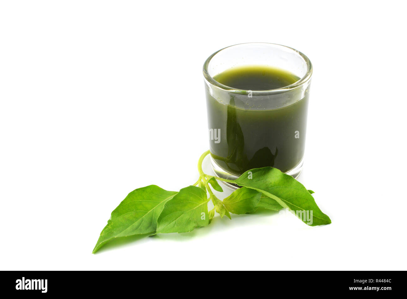 L'eau de jus de légumes herbes vert / vert légumes feuilles de basilic herbes extrait à l'eau dans le verre sain isolé sur fond blanc Banque D'Images