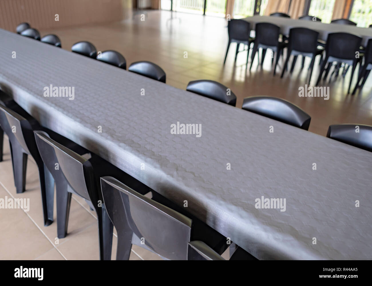 Tourné d'une rangée de chaises gris plastique autour des tables couvertes de nappes en papier gris s'en préparation des festivités. Banque D'Images