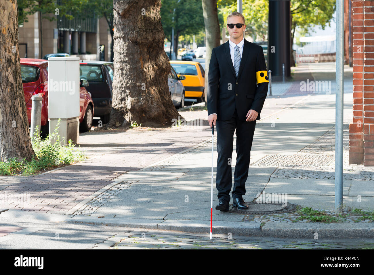 Blind Man Walking on Sidewalk Holding Stick Banque D'Images
