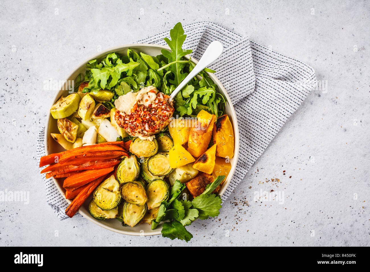 Les légumes cuits et l'hoummos salade dans un plat blanc, vue du dessus. La nourriture végétalienne saine concept. Banque D'Images