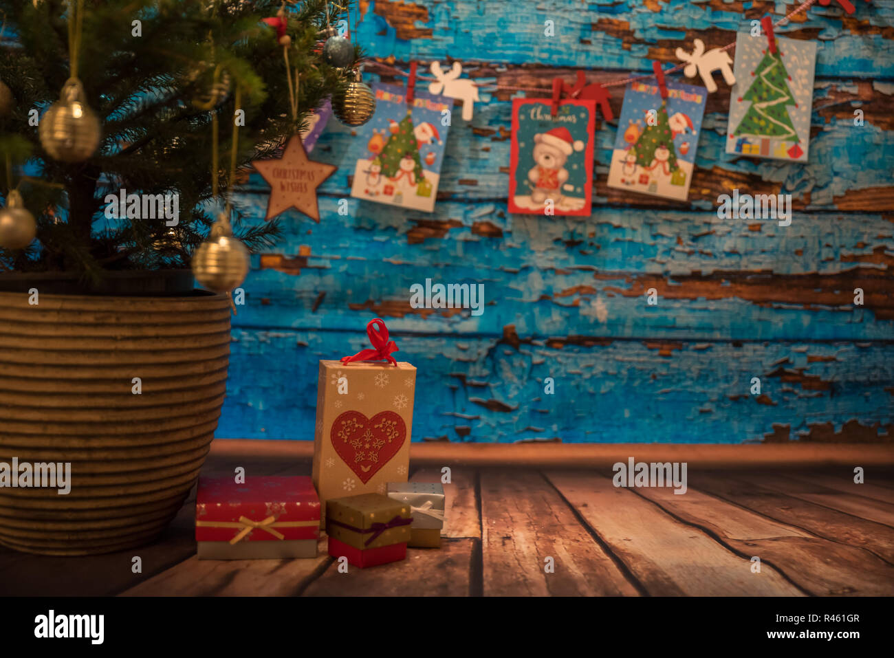 Haywards Heath, en Angleterre, le 14 décembre 2016. Arbre de Noël, boîtes-cadeaux sur plancher en bois, des cartes de Noël en arrière-plan. Banque D'Images