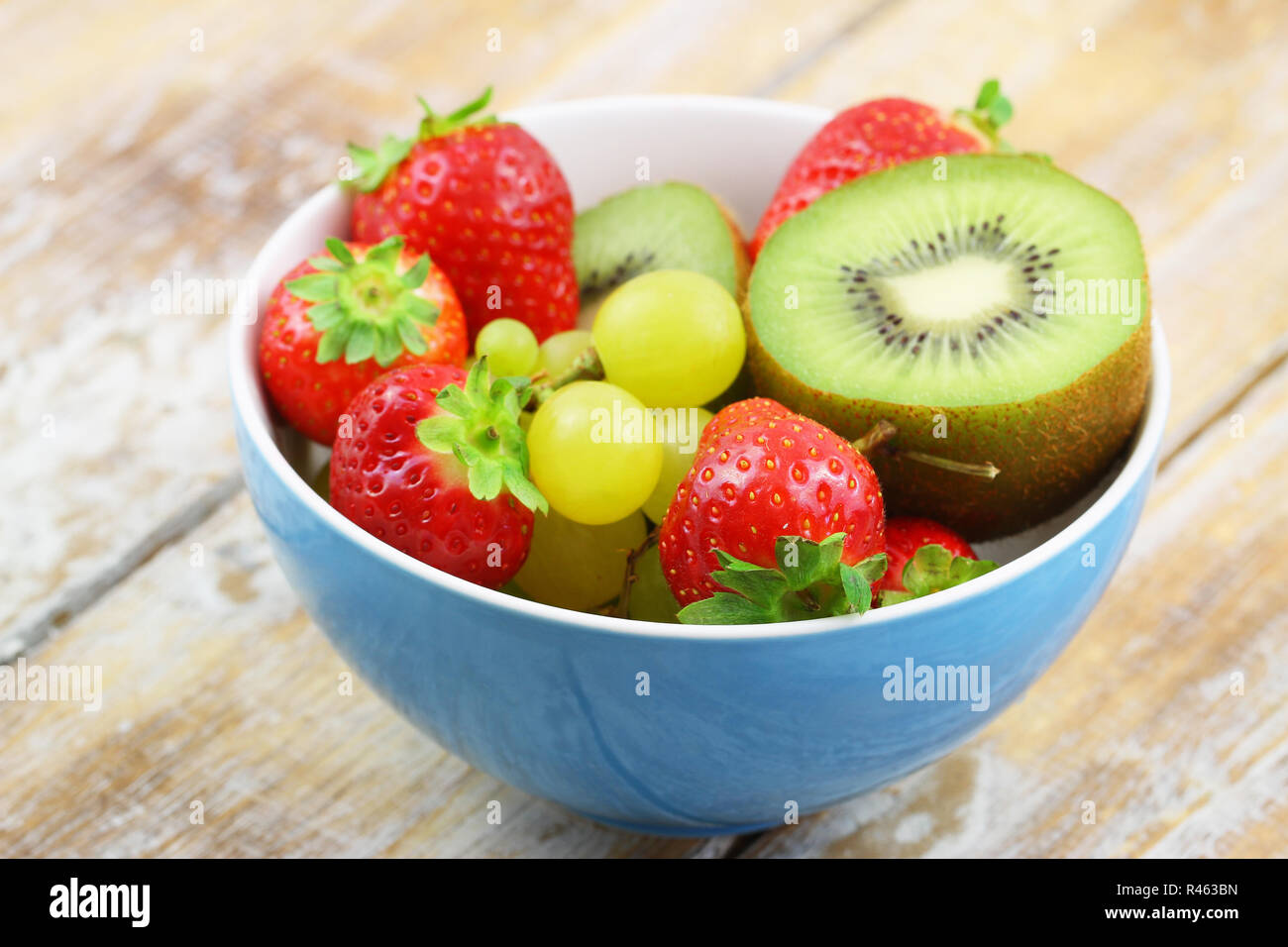 Plein bol de fruits : fraises, kiwis et raisins Banque D'Images