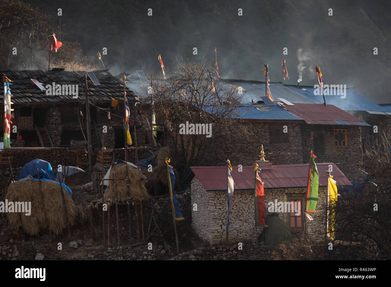 La fumée des feux de cuisson de base de l'habitation en Lho, Népal Banque D'Images