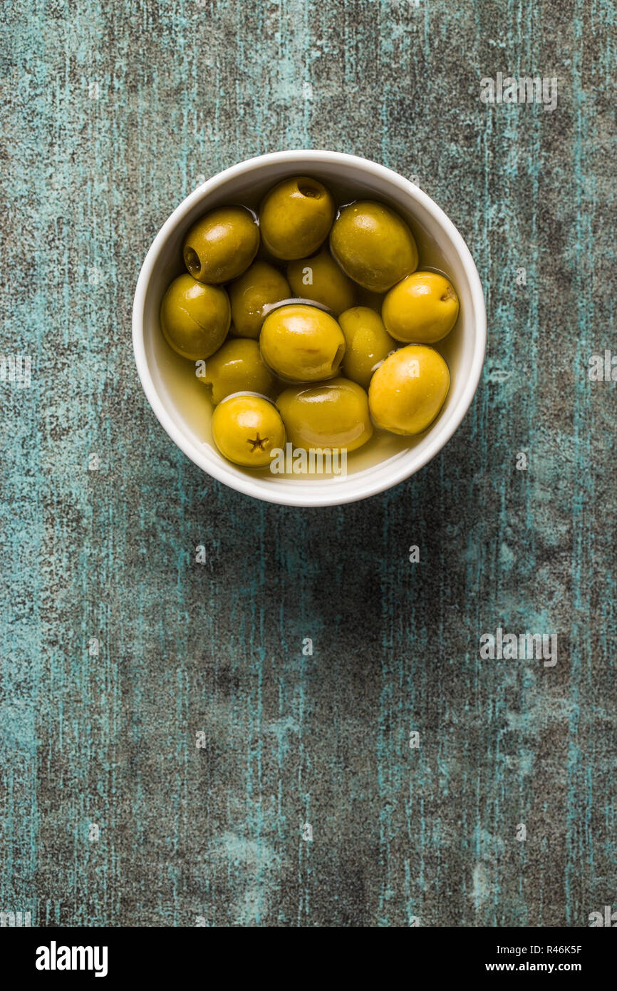 Olives vertes marinées dans un bol. Vue d'en haut. Banque D'Images