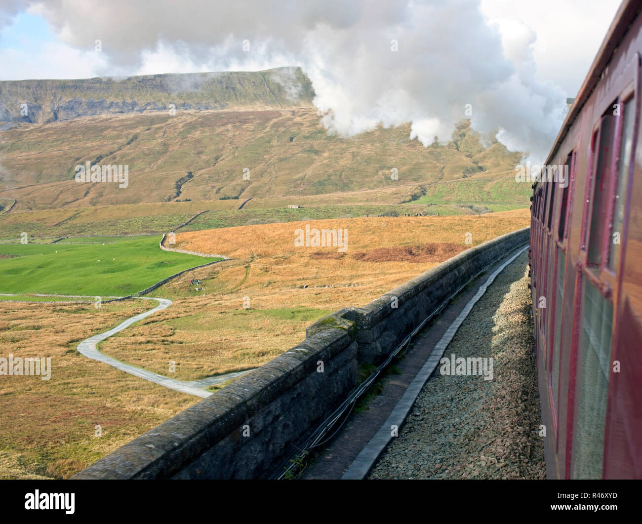 Vue d'un train à vapeur du patrimoine tout en allant sur un viaduc sur la ligne de chemin de fer s'établir/Carlisle, West Yorkshire, Angleterre, Royaume-Uni. Banque D'Images